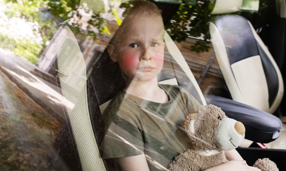 Child with Red Cheeks in a Booster Seat; a sign of overheating
