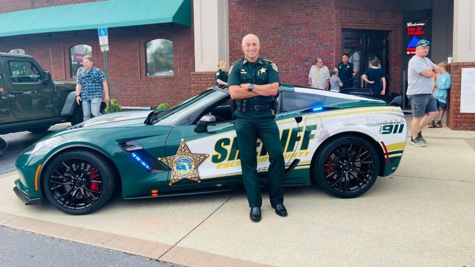 Chip Simmons of the Escambia County Sheriff's Office standing by the seized 2017 Chevy Corvette Z06 wrapped in police decals