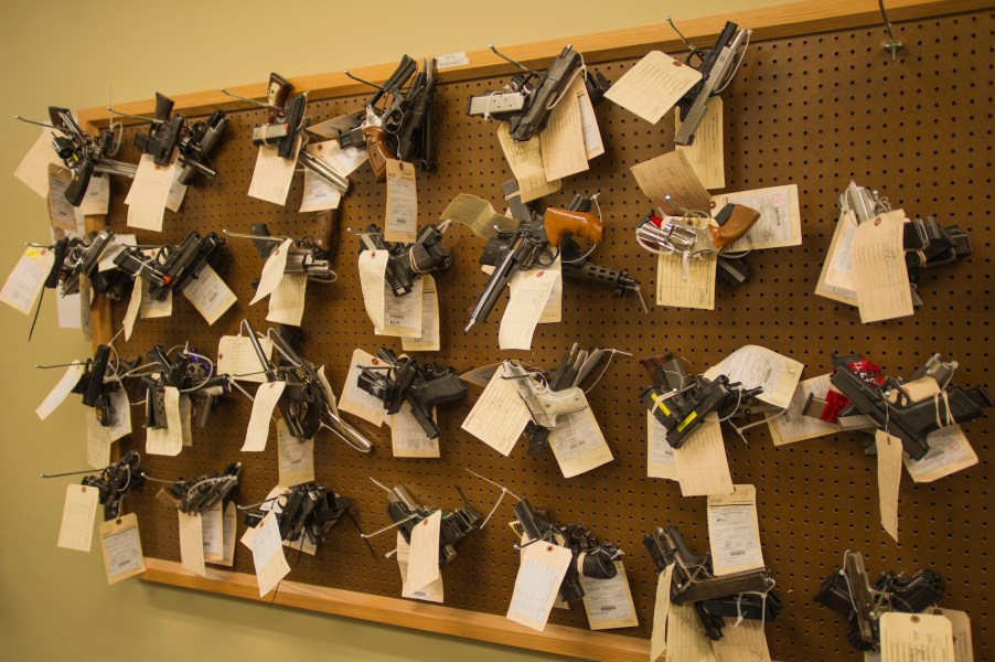 Confiscated guns, potentially stolen guns, hanging on a wall.