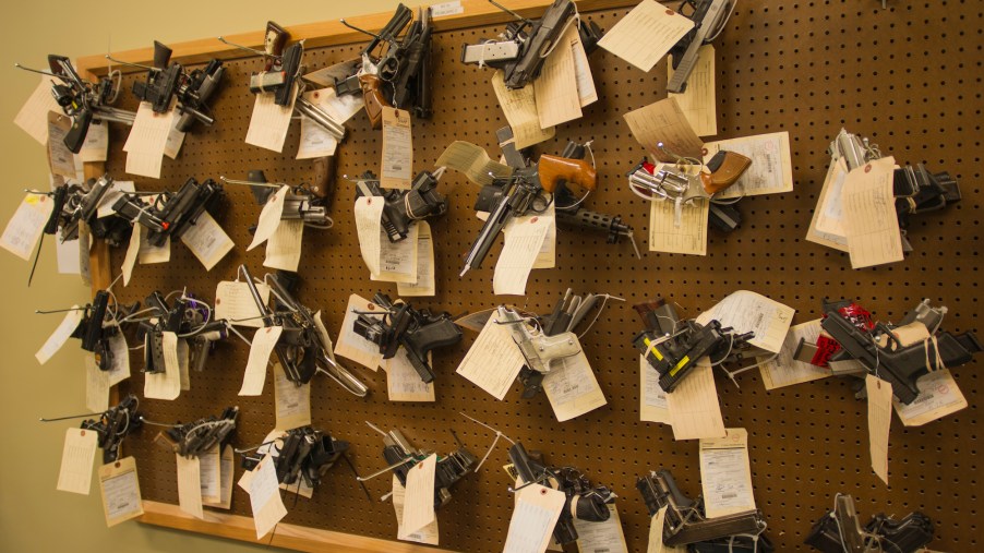 Confiscated guns, potentially stolen guns, hanging on a wall.