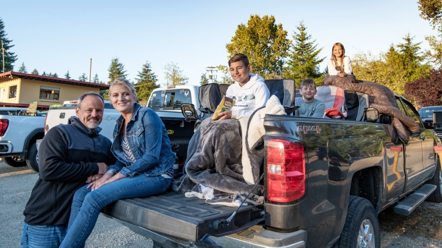 Family Enjoying Drive-In Movie Truck Using the Tailgate as a Seat