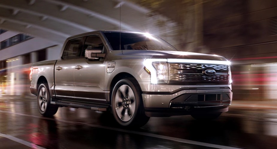 A gray 2022 Ford F-150 Lightning drives down the road.