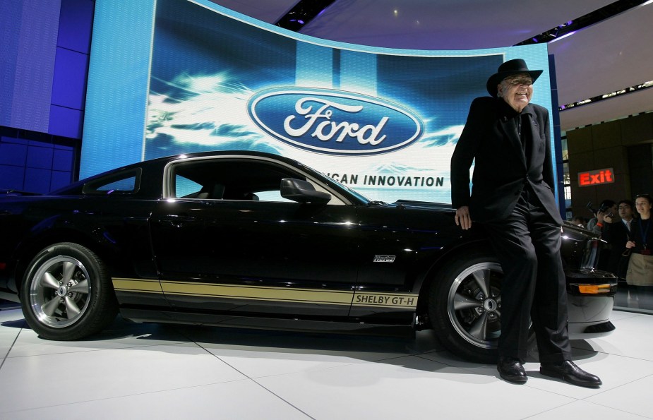 Carroll Shelby poses with a Shelby GT-H at an auto show.