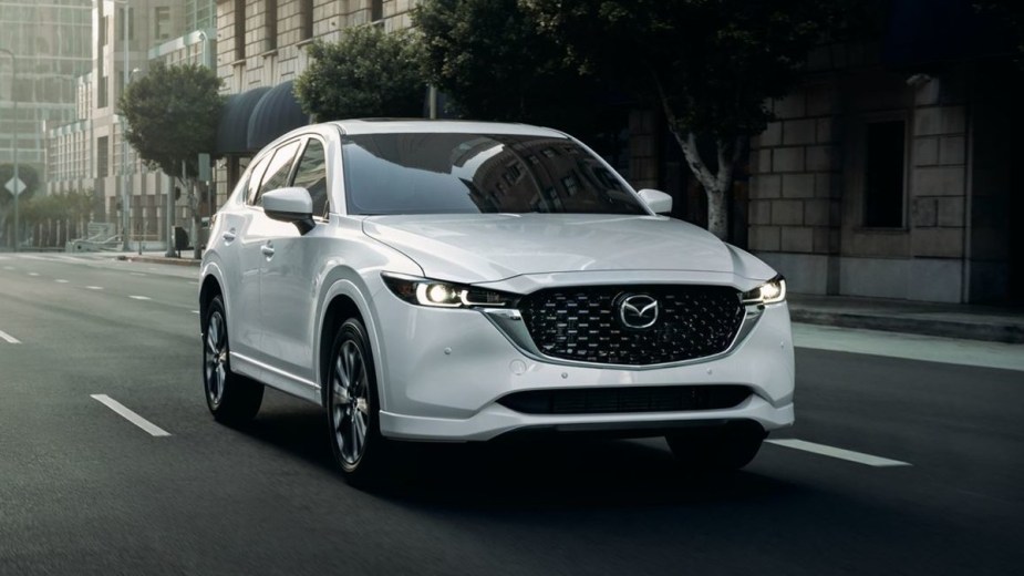 Corner front view of the Rhodium White 2023 Mazda CX-5, highlighting its release date and price