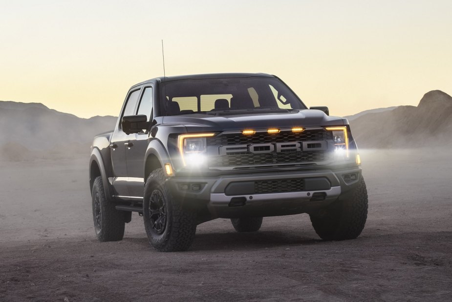 Front angle view of a dark gray Ford F-150 Raptor, a modern car with a mean and angry face