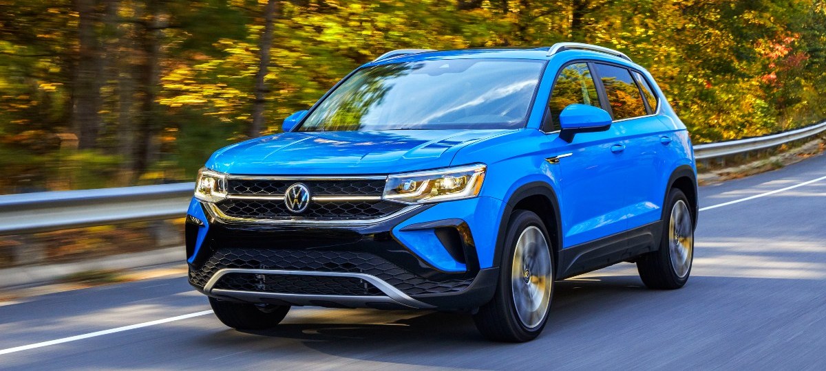 Front angle view of blue 2023 Volkswagen Taos, highlighing its release date and price