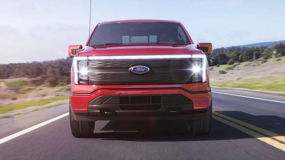 Front view of red 2022 Ford F-150 Lightning, highlighting electric road in Detroit that can charge an EV