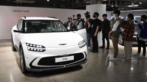 A white Genesis GV60 parked indoors.