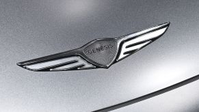 A silver 2023 Genesis GV60 logo on a silver car.