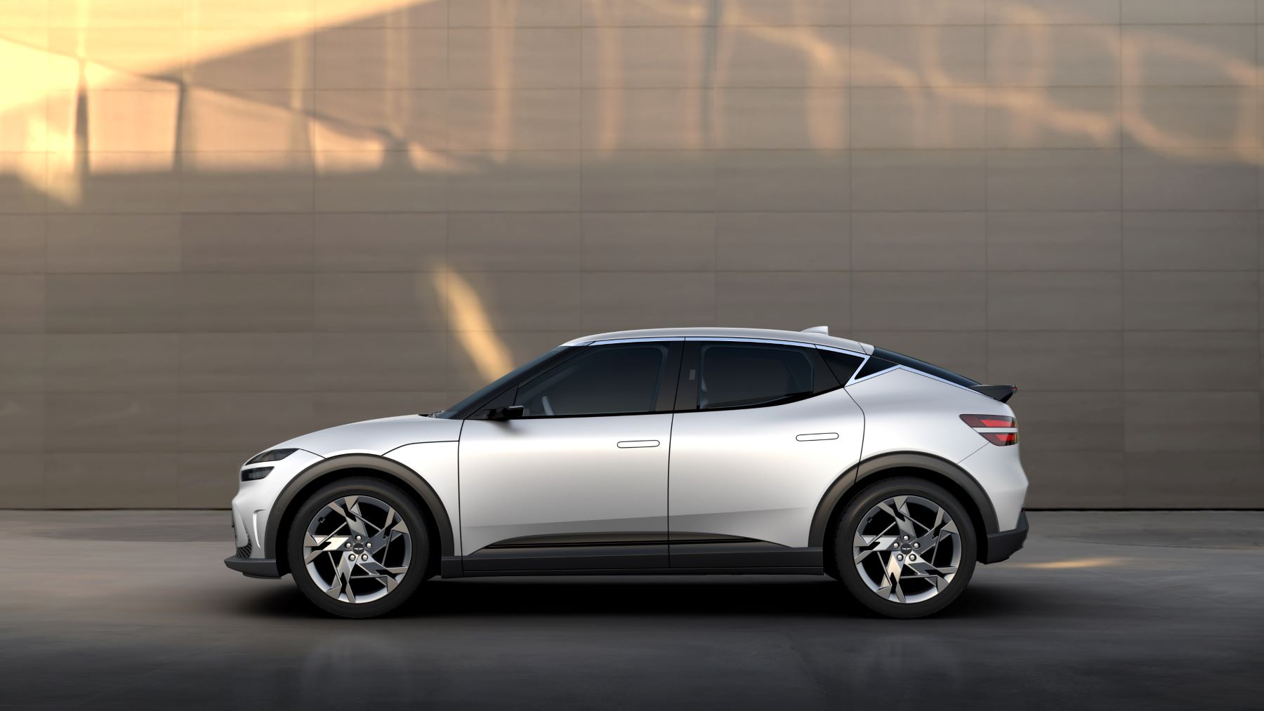 A side profile and promotion shot of the Genesis GV60 compact electric SUV