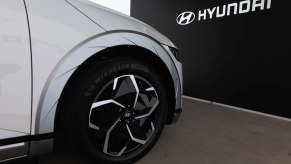 A silver Hyundai parked in front of a black background with Hyundai written on it.
