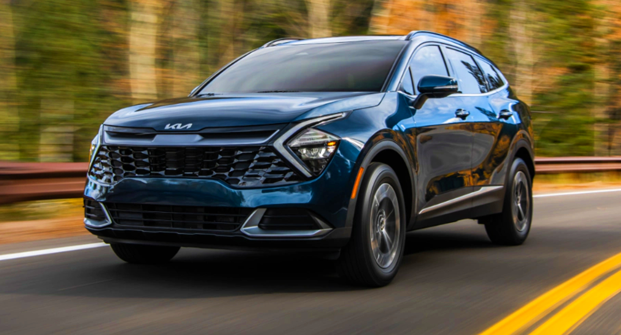 A blue 2023 Kia Sportage Hybrid SUV is driving on the road.