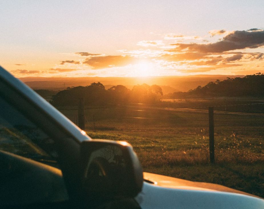 Light from a sunset shines on a car, highlighting driving for creative thinking for big ideas