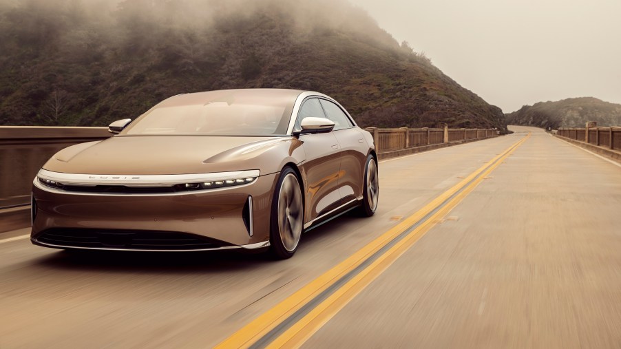 The Lucid Air, like this one, cruises down a back road.