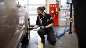 A Valvoline worker checks a car's tire pressure as part of regular maintenance