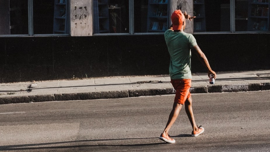 Man jaywalking across a wide street, highlighting whether or not jaywalking is still illegal