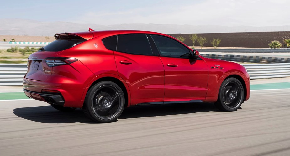 A red 2022 Maserati Levante Trofeo is driving on a track. 