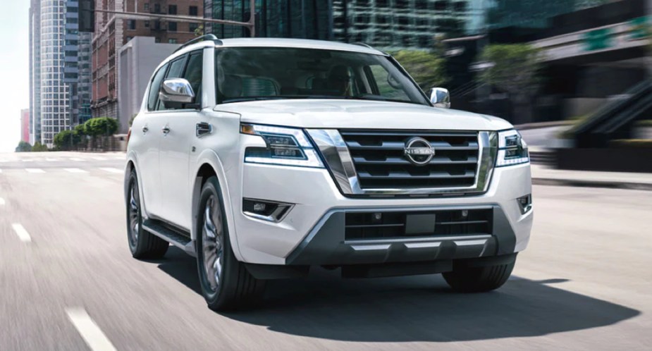 A white 2022 Nissan Armada full-size SUV is driving on the road. 