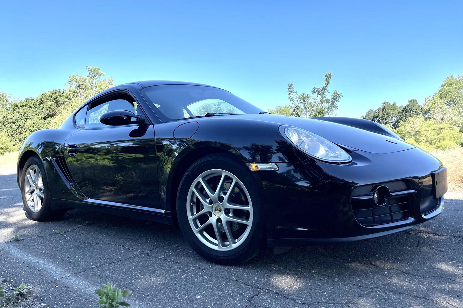 Black 2007 Porsche Cayman front 3/4 parked in parking lot for Cars and Bids auction photos