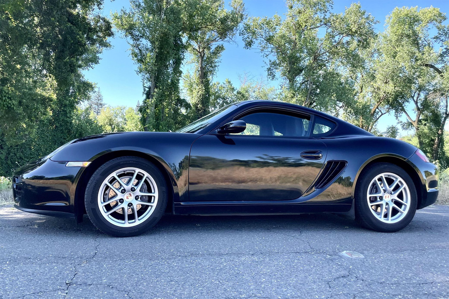 Side biew of black 2007 Porsche Cayman in parking lot for Cars and Bids Auction