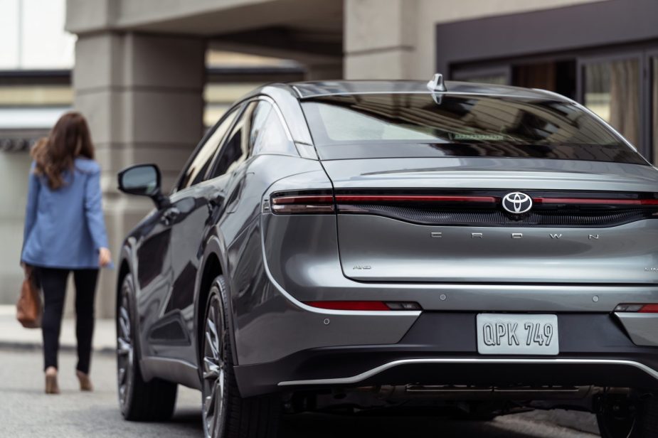 Rear angle view of silver 2023 Toyota Crown SUV-like sedan, highlighting its release date and price