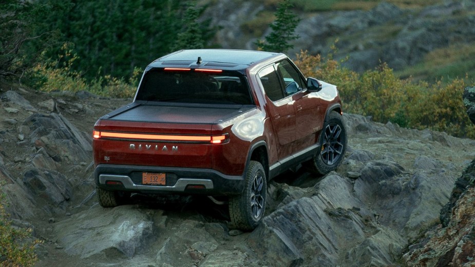 Orange 2022 Rivian R1T electric pickup truck goes off-road, highlighting its Off-Roadside Assistance plan