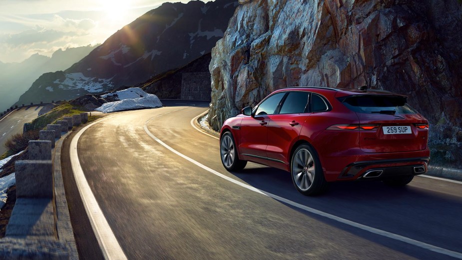 Red 2023 Jaguar F-PACE luxury SUV driving on a mountain road, highlighting its release date and price