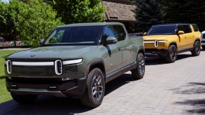 Rivian R1T parked in front of a yellow Rivian SUV