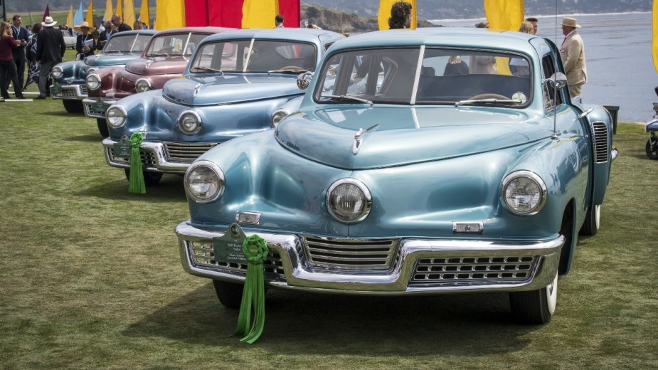 Row of 1948 Tucker 48 Sedans at Pebble Beach Concours d'Elegance, highlighting why cars now have two headlights 