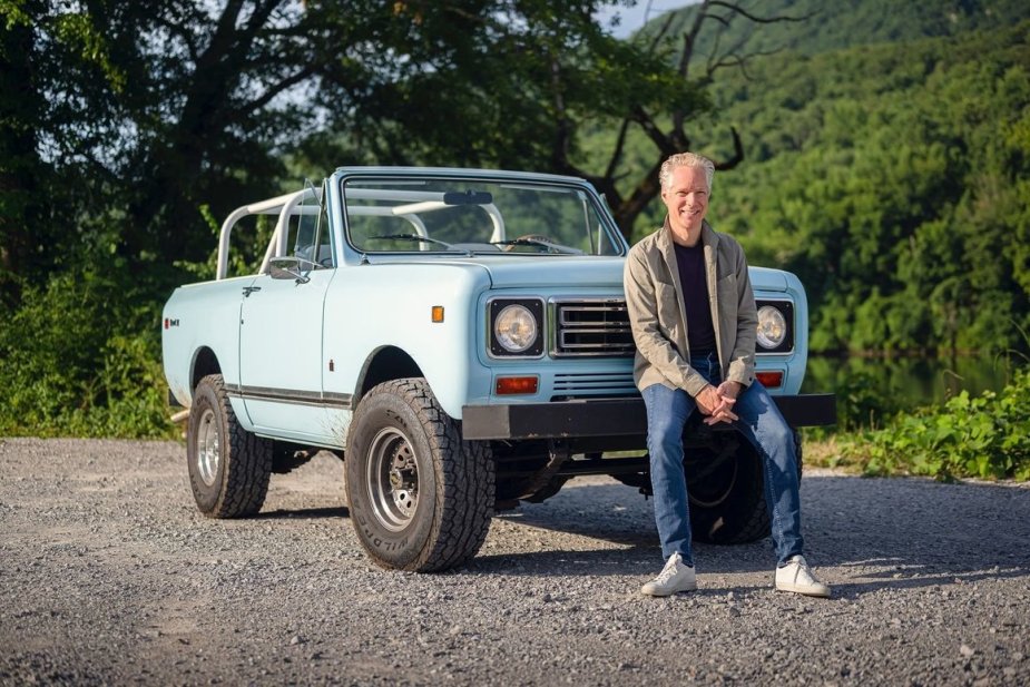 the Scout Motor CEO sitting on a vintage Scout SUV