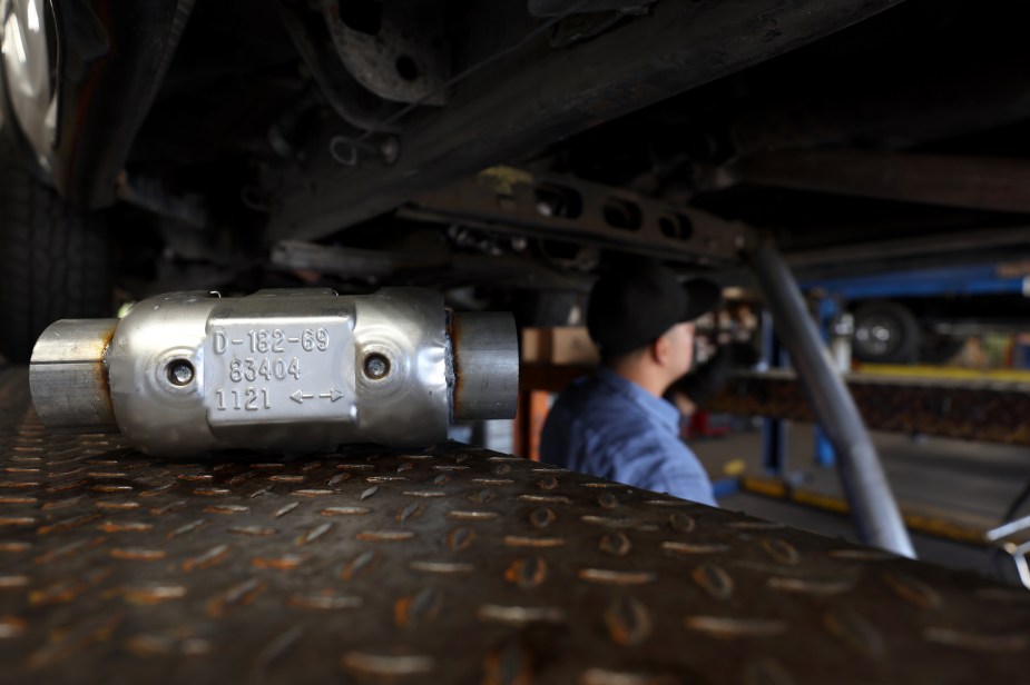 A new catalytic converter sits on a mechanic's lift