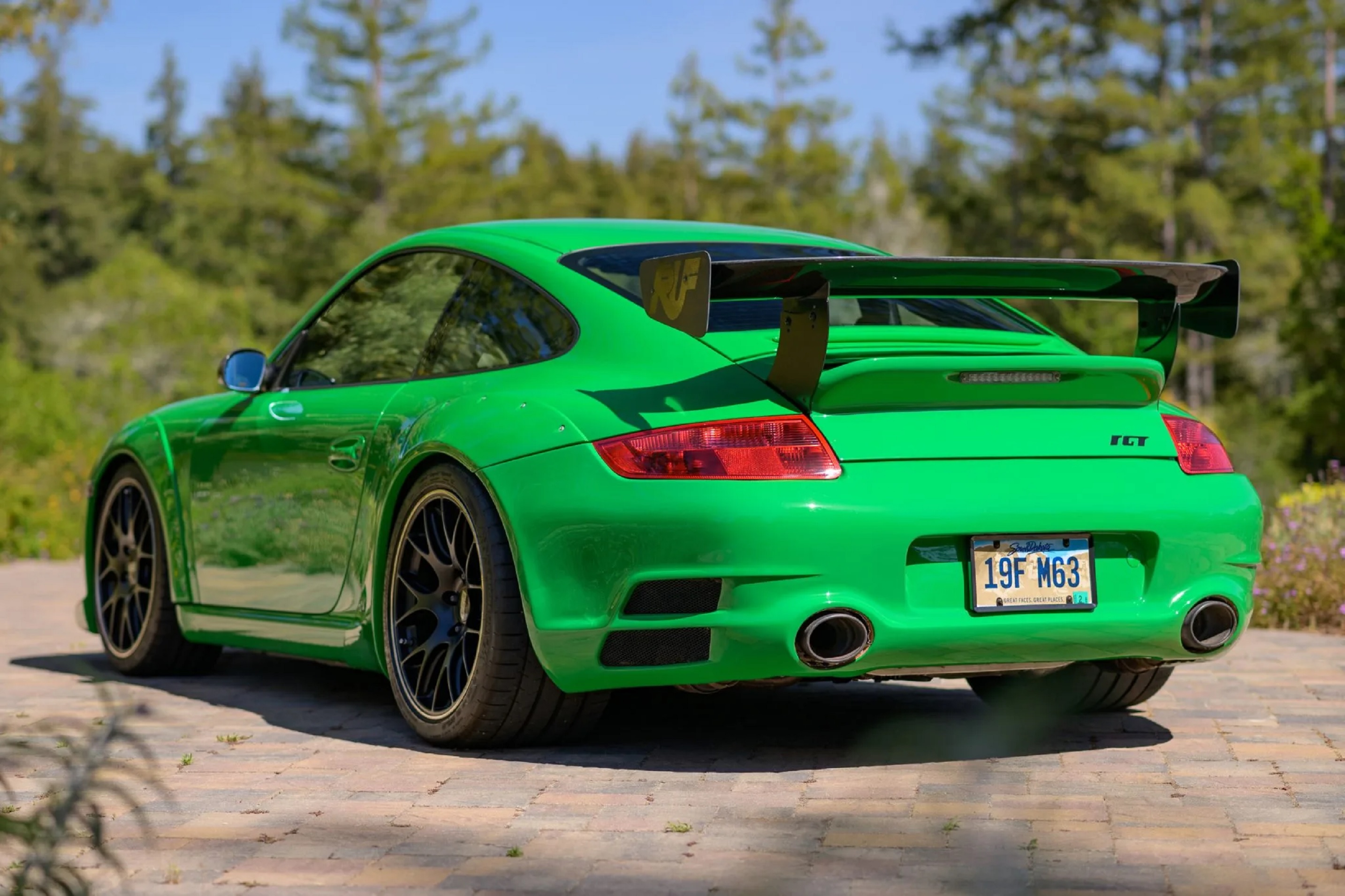 The rear 3/4 view of a Viper Green Sharkwerks-modified 2007 RUF RGT in a desert parking lot