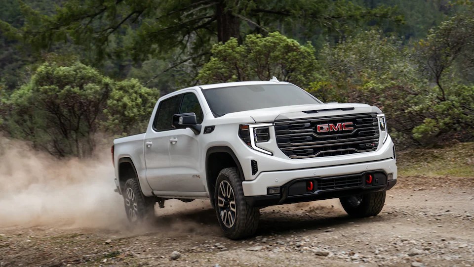 White 2022 GMC Sierra 1500 Denali driving on dirt road.  Is it worth the price?