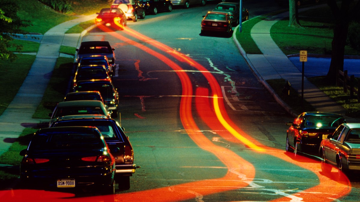 Streaks of light from the taillights of a car, highlighting smartphone apps for reporting aggressive and dangerous drivers