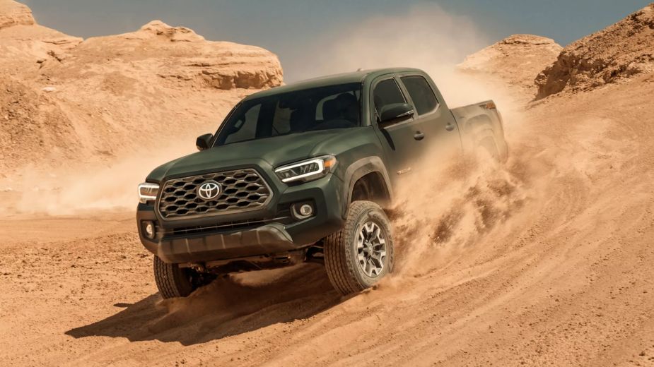 A green 2022 Toyota Tacoma off-roading. Is KBB's best midsize truck the most popular for a good reason?