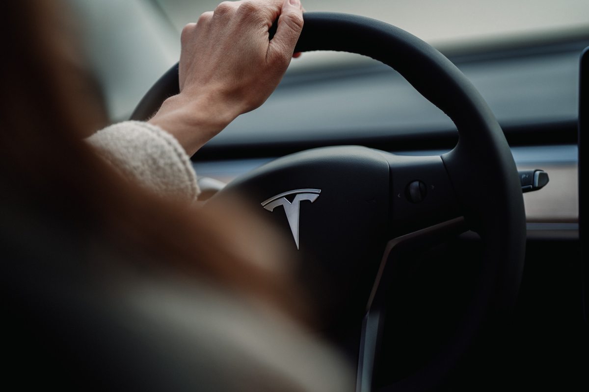 The Tesla logo shown on a steering wheel of a luxury car