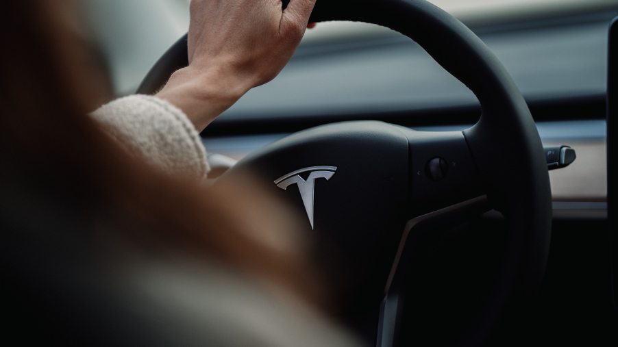 The Tesla logo shown on a steering wheel of a luxury car