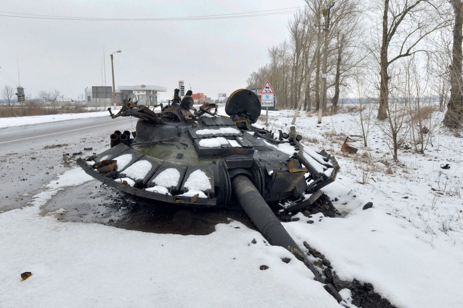 The destroyed turret of a Russian tank, discarded and covered in snow by the side of a Ukrainian road.