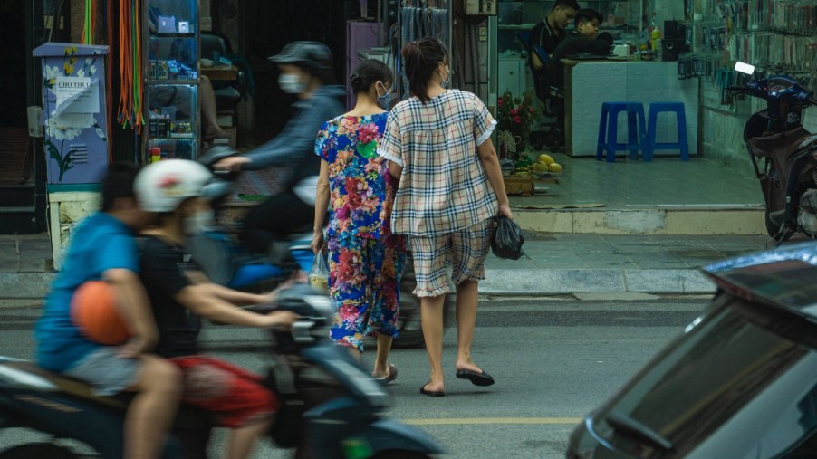 Two women jaywalking across a street, highlighting whether or not jaywalking is still a crime