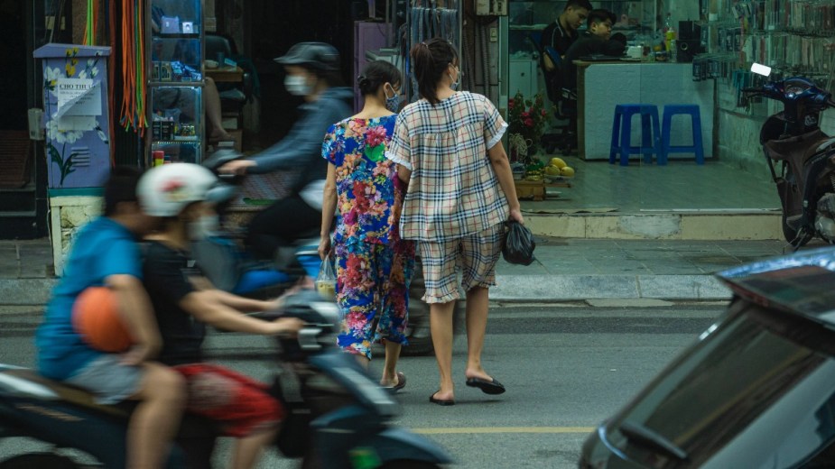 Two women jaywalking across across a street, highlighting whether or not jaywalking is still a crime