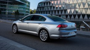 A silver Volkswagen Passat midsize sedan driving down a highway during the day