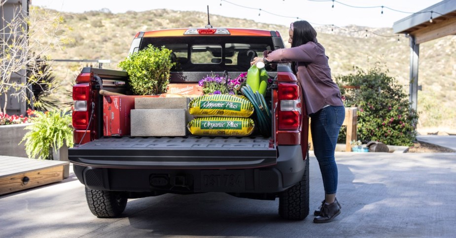 Woman loading up the pickup bed of 2023 Ford Maverick, highlighting its release date and price