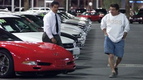 A customer checks out a used Corvette at a dealership.