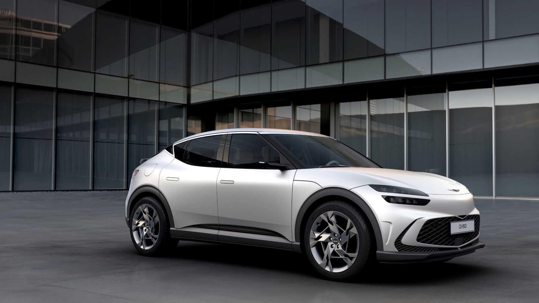 The Genesis GV60 luxury electric compact SUV parked outside a glass office building