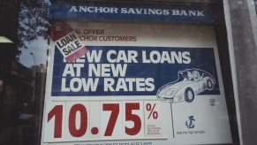 A sign in the window of the Anchor Savings Bank advertising car loan rates.