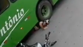 Motorcycle rider with his under a bus tire
