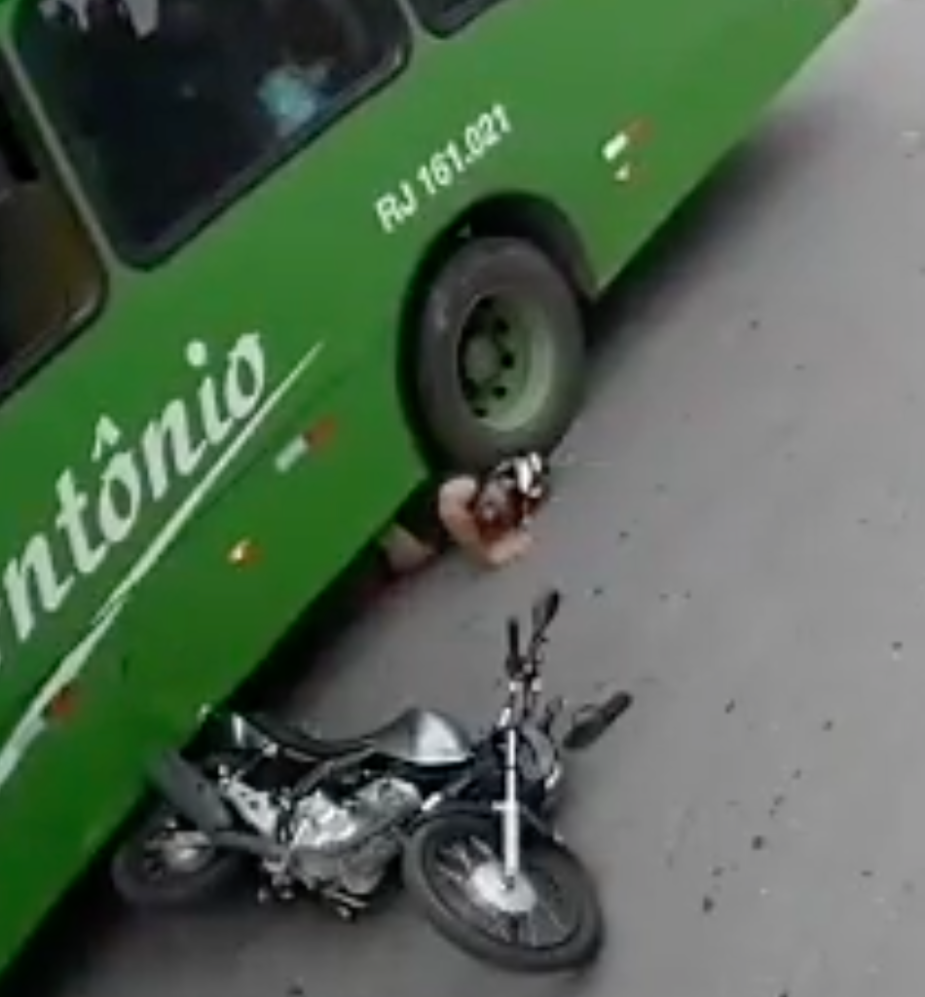 Motorcycle rider with his under a bus tire 