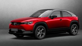 A promotional design shot of a red 2022 Mazda MX-30 electric SUV model