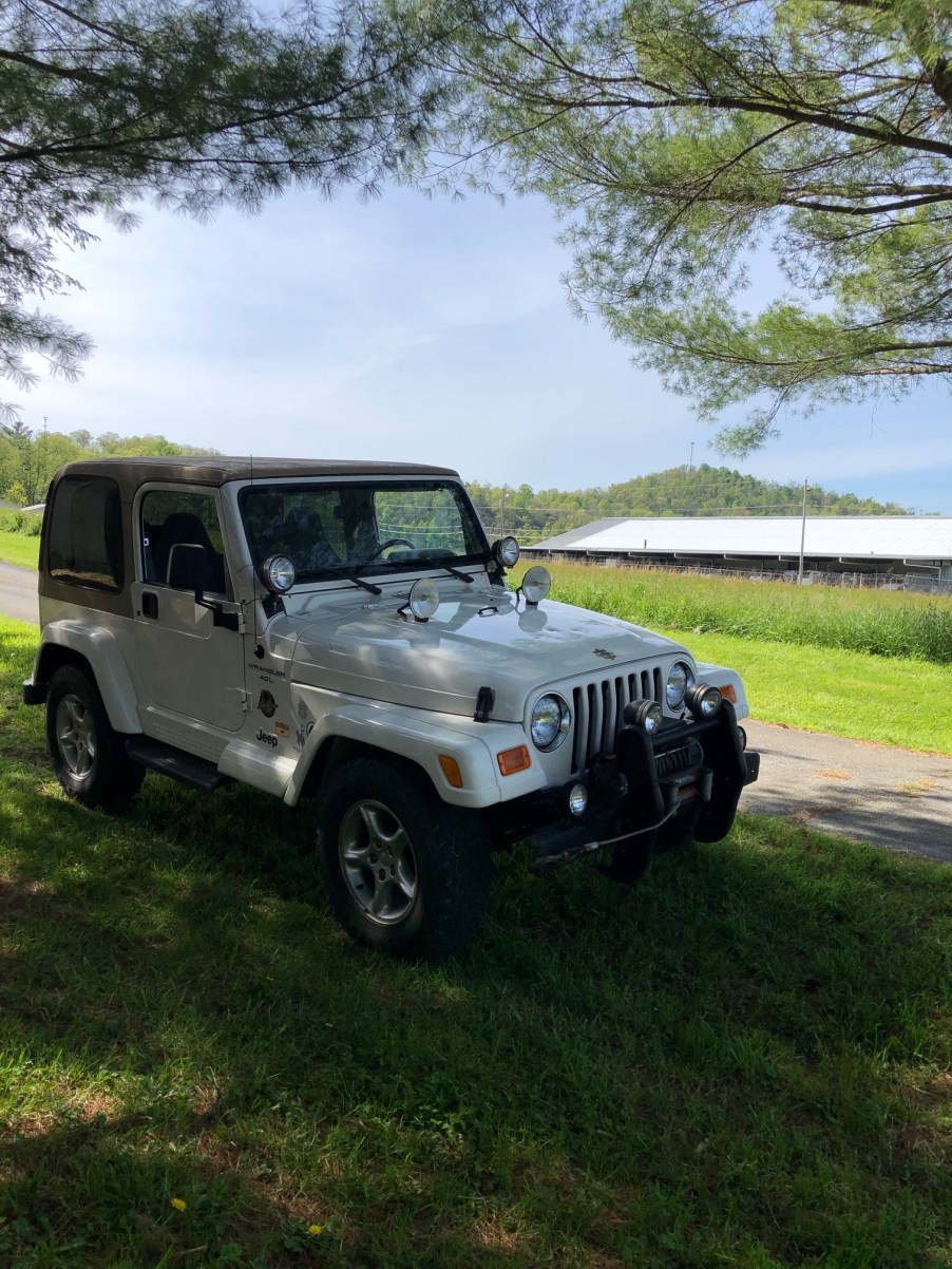 A white 2000 Jeep Wrangler in a field