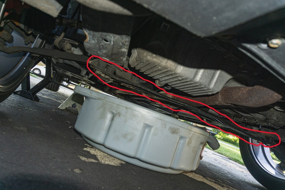The underside of a 2013 Fiat 500 Abarth with the black lower subframe brace highlighted in red